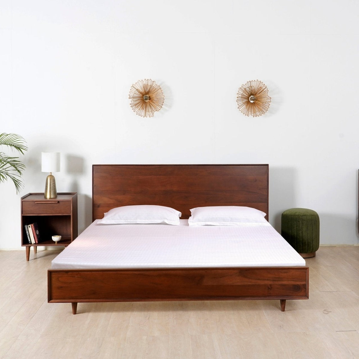 Bedroom with wooden bed and dresser against a white wall